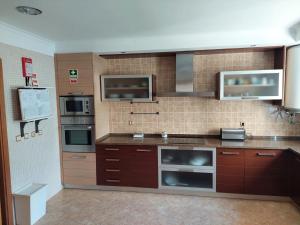cocina grande con armarios y electrodomésticos marrones en A Family house in Santa Cruz, Torres Vedras en Silveira
