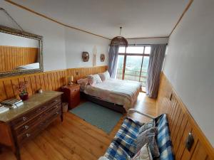 a bedroom with a bed and a mirror and a couch at Vichuquén Mágico in Vichuquén