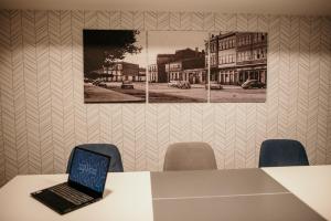 een laptop op een tafel met stoelen bij Hotel Lux Melide in Melide