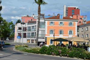 a city street with a palm tree and buildings at Apartma Sunlight in Koper