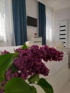 salon z fioletowymi kwiatami przed łóżkiem w obiekcie Vernatun guest house w mieście Giumri