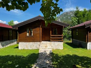 ヴィルパザルにあるOrahovo Cottagesの山を背景にした小さな木造家屋