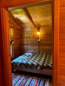 a bedroom in a log cabin with a bed in it at Orahovo Cottages in Virpazar