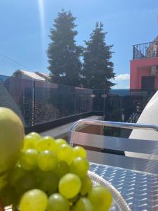 a bowl of green grapes on a table with a view at Alma Rose Apartment in Korçë