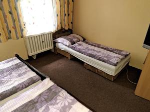 Zimmer mit 3 Betten und einem Fenster in der Unterkunft Vila v Modre-Harmónii in Modra