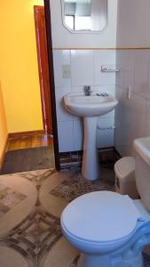 a bathroom with a toilet and a sink at Hosteria LAS ISLAS in Comunidad Yumani