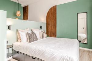 una camera da letto con un grande letto bianco e uno specchio di Japandi, Appartamento Zona Porto Mediceo Livorno a Livorno