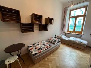 a living room with two beds and a table at H. Kloss Rooms in Łódź