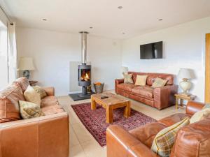 a living room with leather furniture and a fireplace at Lurach House - Ukc6791 in Port Appin