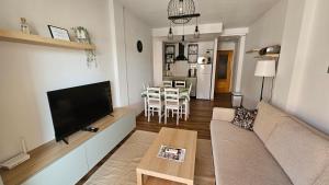 a living room with a couch and a tv and a table at Rodas Apartment in Torrevieja