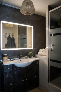 a bathroom with a sink and a mirror at COCOONING SPA - Gîte avec piscine, jacuzzi, sauna in Marck