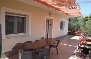 patio z drewnianym stołem i krzesłami na patio w obiekcie Garden Apartment Braut w mieście Kornić