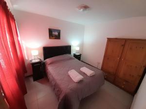een slaapkamer met een bed met twee handdoeken erop bij M I L I Departamento en Mendoza in Godoy Cruz