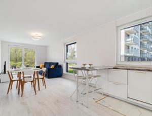 uma cozinha e sala de estar com mesa e cadeiras em Apartament blisko morza em Gdansk