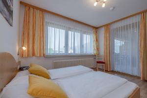 a bedroom with a large bed and two large windows at Haus Scheiblauer in Tröpolach +169 photos