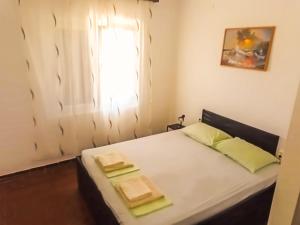 a small bedroom with a bed with a window at Mila Pet friendly house with private beach place in Pag