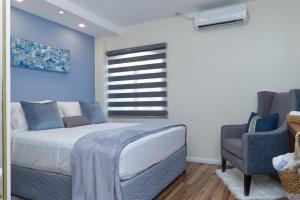 a bedroom with a bed and a chair and a window at The Cozy Condo in Arouca