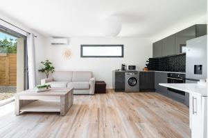 a white living room with a couch and a kitchen at Charmante Maison entre Cannes et Nice in Le Bar-sur-Loup