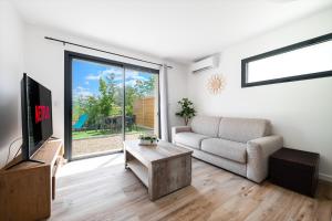 a living room with a couch and a tv at Charmante Maison entre Cannes et Nice in Le Bar-sur-Loup