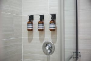 four bottles of essential oils are on a wall in a shower at The Cozy Condo in Arouca