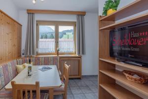 a dining room with a table and a television at Haus Scheiblauer in Tröpolach