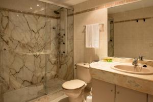 a bathroom with a shower and a toilet and a sink at Hotel Capri in Tossa de Mar +98 photos