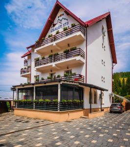 a building with balconies and plants on it at Chalet 173 in Gura Humorului