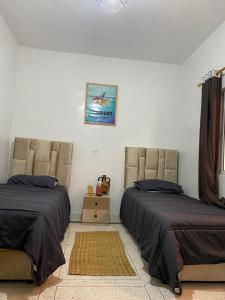 a bedroom with two beds and a picture on the wall at K11 hostel in Agadir