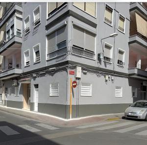a white building with a car parked in front of it at Apartamento tipo loft valencia in Paiporta