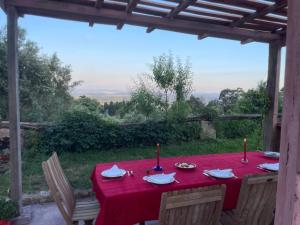 una mesa con un mantel rojo y velas en ella en AltaVista, en Vitorino dos Piães