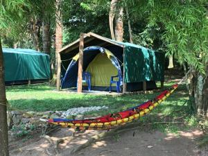 a hammock in front of a tent in a field at Banda Island Resort and Campsite in Kalangala