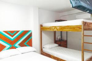 サンタ・マルタにあるCasa Liz Hotel Boutiqueの白い壁の小さな部屋の二段ベッド2台