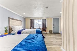 a hotel room with two beds and a table at Tides Motel - Hampton Beach in Hampton