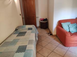 - une chambre avec un lit et une chaise rouge dans l'établissement La Panoramica, à Gallodoro