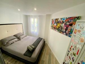 1 dormitorio con 1 cama con una pintura en la pared en Villa Heritage en Beausoleil