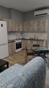 a kitchen with a table and chairs and a refrigerator at Vasiliki Studios Tolo in Tolo