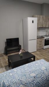 a kitchen with a table and a white refrigerator at Vasiliki Studios Tolo in Tolo +3 photos