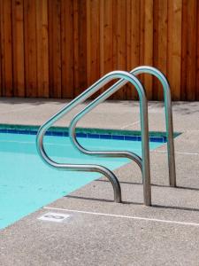 a metal bench next to a swimming pool at Dawn Ranch in Guerneville
