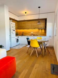 a kitchen with a dining table and yellow chairs at Lizz Panoramic Residence in Floreşti
