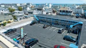 un parcheggio con auto parcheggiate di fronte a un edificio di Tides Motel - Hampton Beach a Hampton Beach