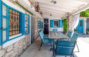 a table and chairs on a patio with blue windows at 3 Bedroom Nice Home In Smrika in Šmrika