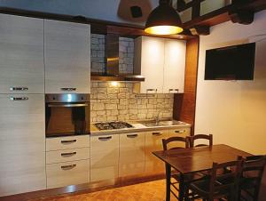 a kitchen with a table and a stove top oven at Appartamento Vacanze Il Daino in Leonessa