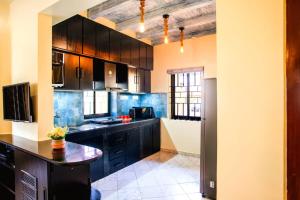 a kitchen with black cabinets and a black counter top at 'Golden Sea Pearl' 1 bhk Beach apartment in Benaulim