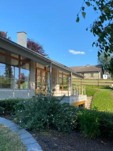 ein Haus mit einer Veranda und einem Hof in der Unterkunft L’Oxymore in Weismes