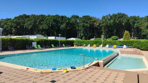 a large swimming pool with blue water and chairs at Le Colorful in Dinard