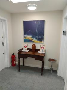 a desk in a room with a painting on the wall at Plaza suite 61 B in Bangor