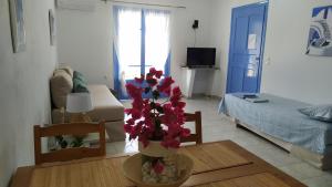 ein Wohnzimmer mit einer Vase mit Blumen auf dem Tisch in der Unterkunft Veranda to Aegean in Ligia