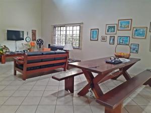 伯迪亚哥RIVIERA-CASA FAMILIAR PERTO DA PRAIA-3 QUARTOS-3 BANHEIROS-ATÉ 10 PESSOAS-Módulo 4的客厅配有长凳和桌子