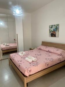 ein Schlafzimmer mit einem rosa Bett mit Handtüchern darauf in der Unterkunft Piccolo fiore B&B in Capaccio-Paestum