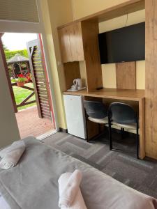 a room with a bed and a kitchen with a desk at ADANIA 1 in Grzybowo
